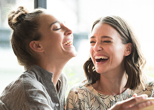 Two women laughing with beautiful smiles